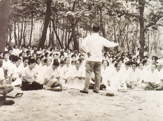 Reverend Moon speaking to members at an outdoor service in Taereung
