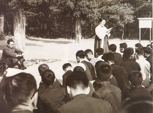 Mrs. Won-bok Choi reading a letter from overseas at an outdoor service