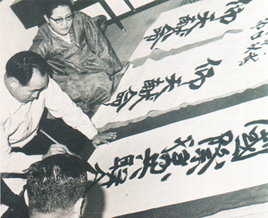 Reverend Moon writing calligraphy for IFVOC