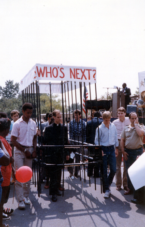 The figure of an imprisoned priest forms part of a protest rally